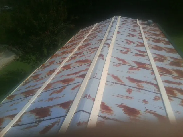 Rusted metal roof panels with new wood purlins before replacement — Storm Damage Roof Repair in Ramah by Roofing Brothers